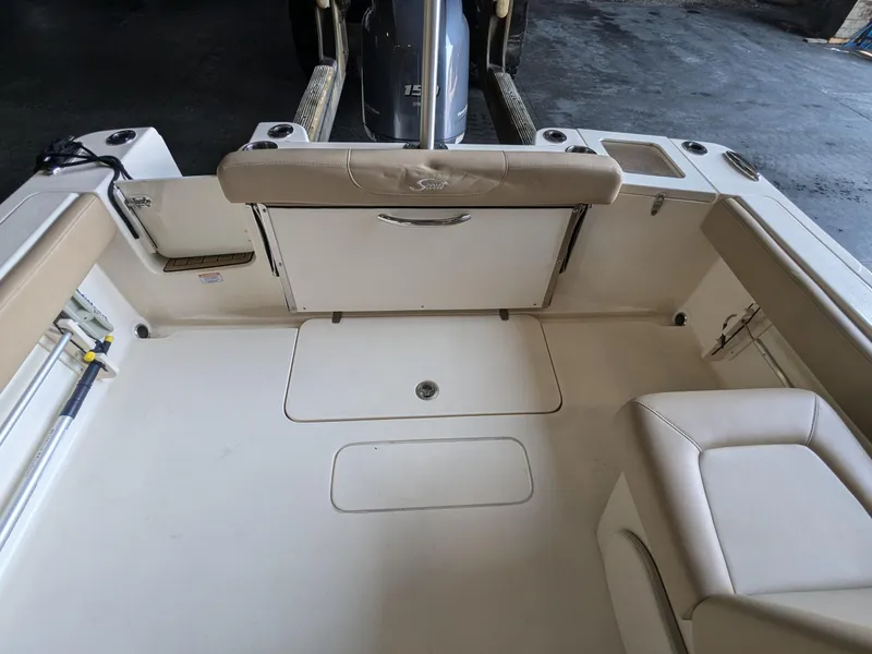 Slide: The Image of 2022 Scout 215 Dorado boat interior with beige seating and storage compartments. - 9