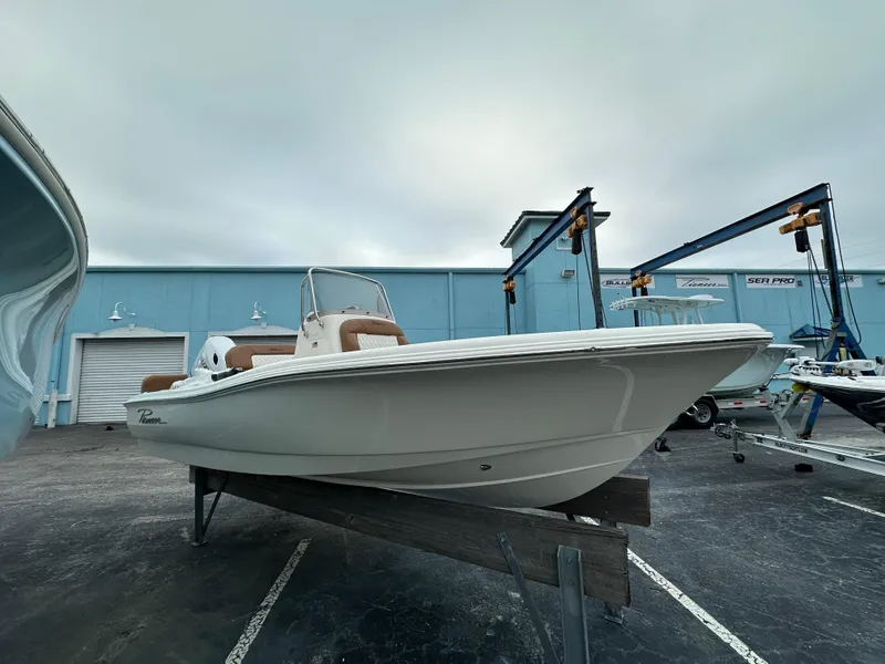 Slide: The Image of 2025 Pioneer 180 Islander boat displayed outdoors on a stand. - 2