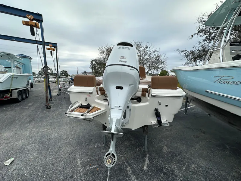 Slide: The Image of 2025 Pioneer 180 Islander boat with outboard motor, parked in a marina. - 3