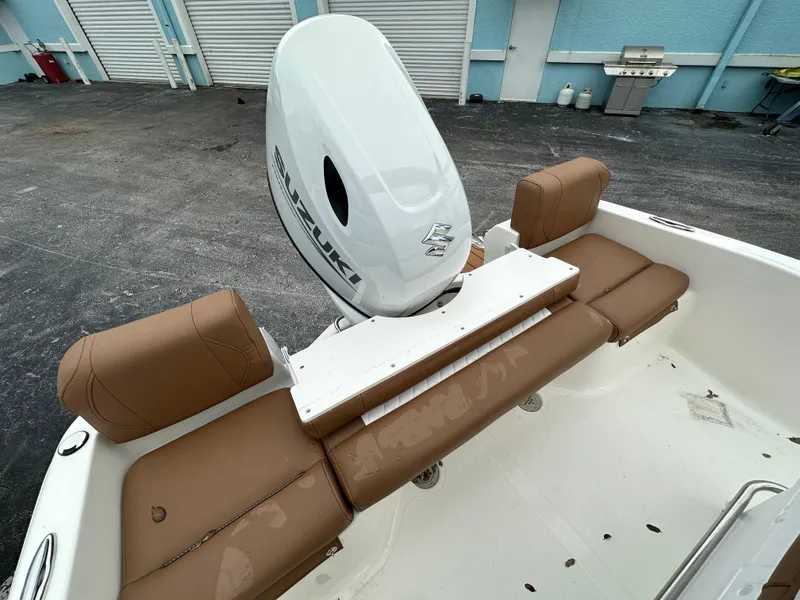 Slide: The Image of 2025 Pioneer 180 Islander boat interior with brown seating and Suzuki outboard motor. - 7