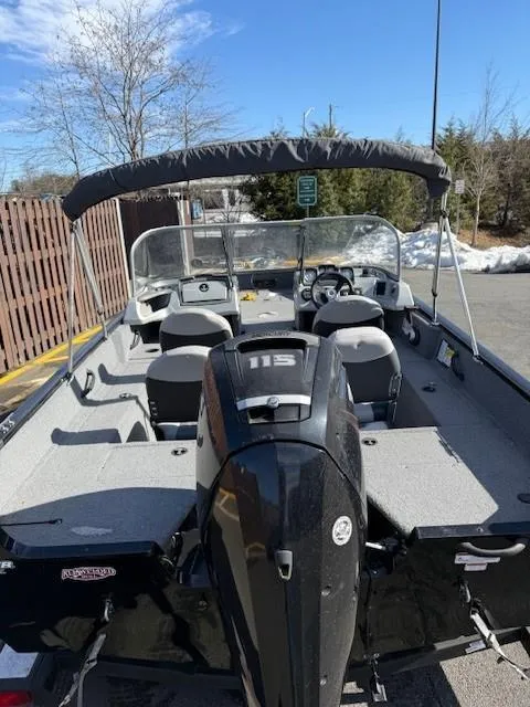 Slide: The Image of 2017 Tracker PGV175 boat with canopy and outboard motor in a parking area. - 7