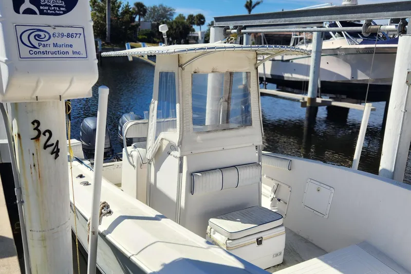 Slide: The Image of 2007 Clearwater 23cc boat docked near water, featuring a center console and seating area. - 1