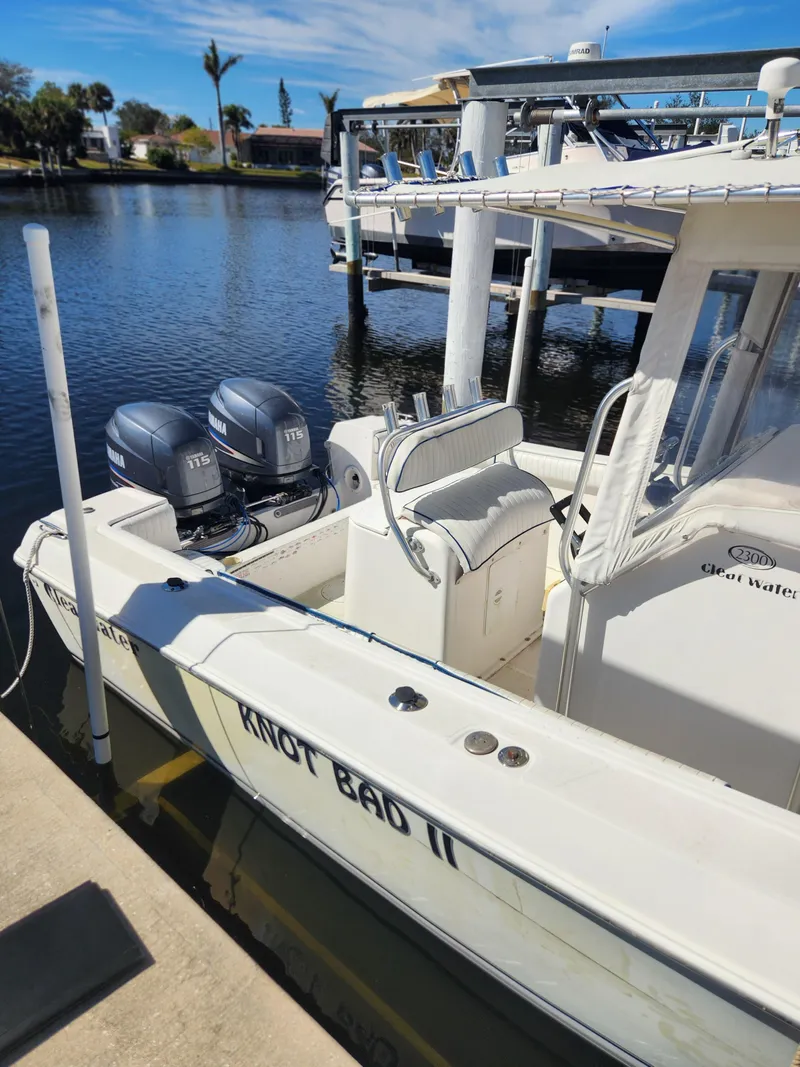 Slide: The Image of 2007 Clearwater 23cc boat docked with twin outboard motors, named "Knot Bad II". - 6