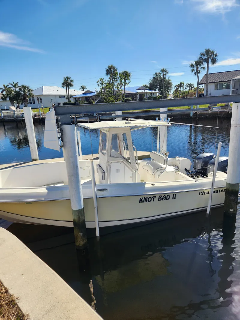 Slide: The Image of 2007 Clearwater 23cc boat named "Knot Bad II" docked in a sunny marina. - 8