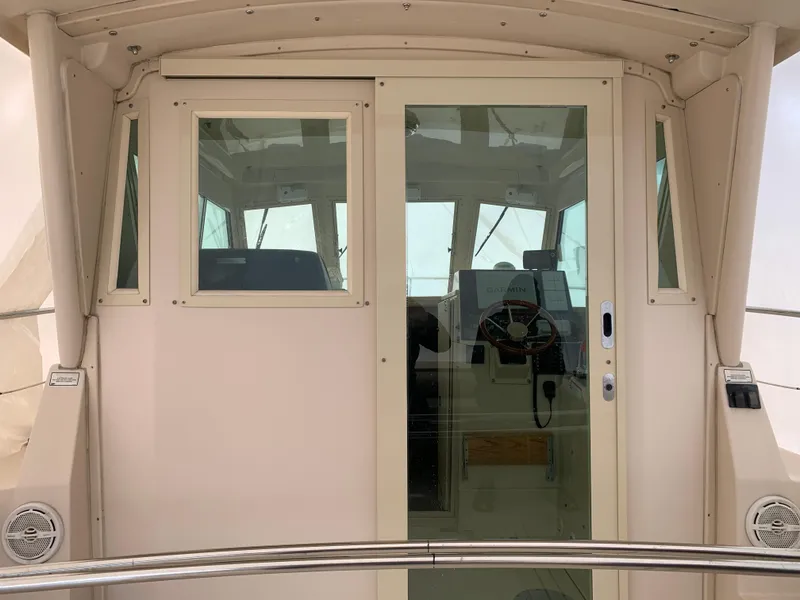 Slide: The Image of 2006 Albin 28 Tournament Express cabin with glass doors and steering wheel visible. - 17