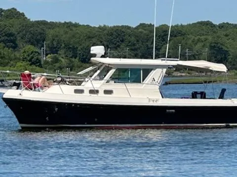 Slide: The Image of 2006 Albin 28 Tournament Express boat on a calm lake with forested background. - 2