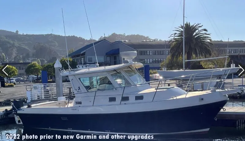Slide: The Image of 2006 Albin 28 Tournament Express docked, pre-upgrade, with scenic marina backdrop. - 6