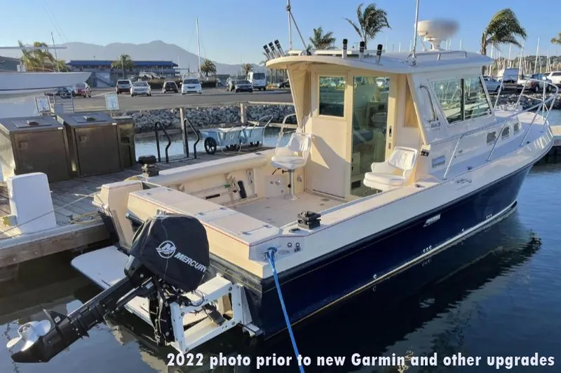 Slide: The Image of 2006 Albin 28 Tournament Express docked, pre-2022 Garmin upgrades, with Mercury outboard motor. - 7