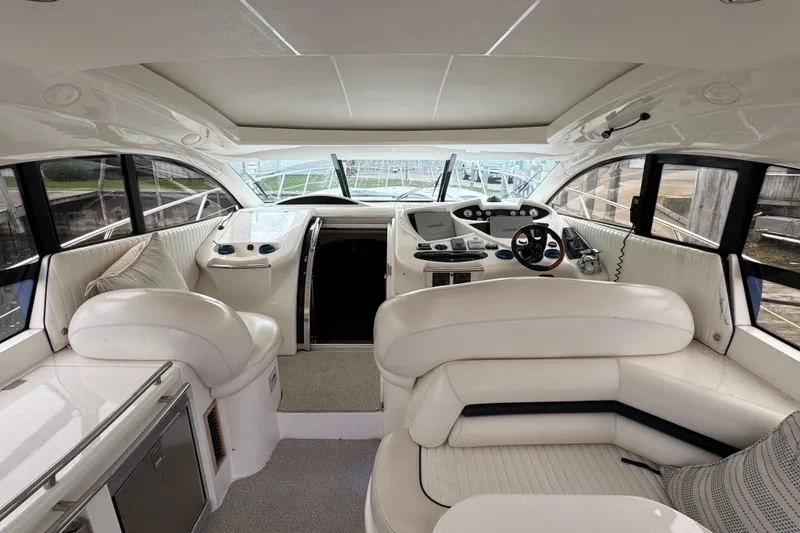 Slide: The Image of Interior of 2003 Sunseeker Predator 62 yacht, featuring luxurious white seating and modern controls. - 21