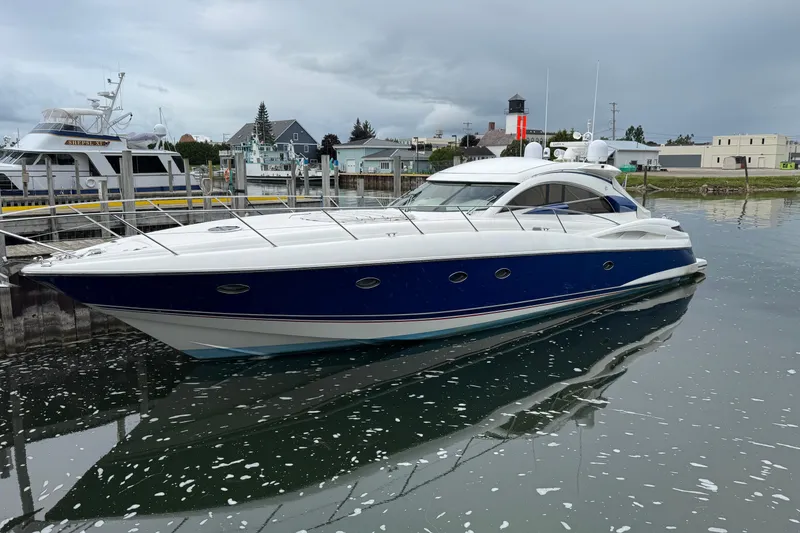 Slide: The Image of 2003 Sunseeker Predator 62 yacht docked in a marina, reflecting on calm water. - 37