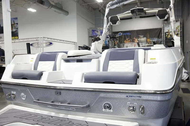 Slide: The Image of 2025 Malibu 26 LSV boat interior with sleek seating and modern design in showroom. - 10