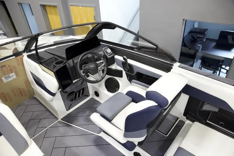 Slide: The Image of Interior of 2025 Malibu 26 LSV boat, featuring modern steering and seating design. - 13
