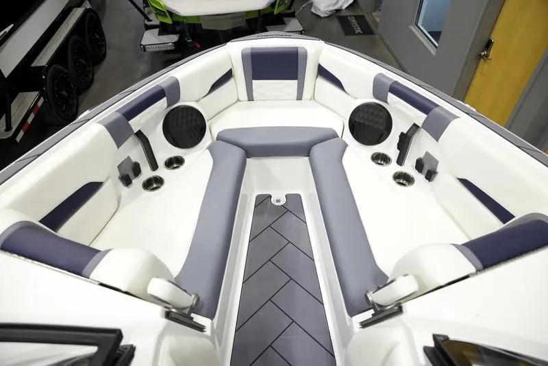 Slide: The Image of 2025 Malibu 26 LSV boat interior with white and gray seating and built-in speakers. - 18