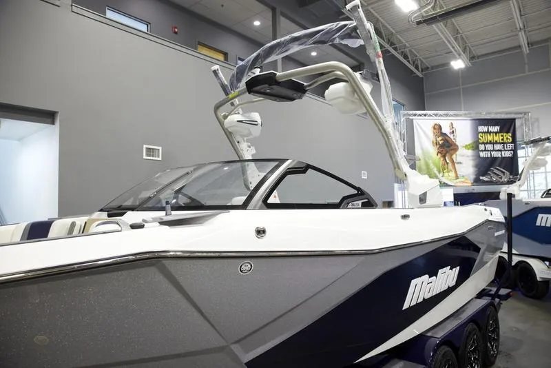 Slide: The Image of 2025 Malibu 26 LSV boat displayed indoors, showcasing sleek design and modern features. - 7