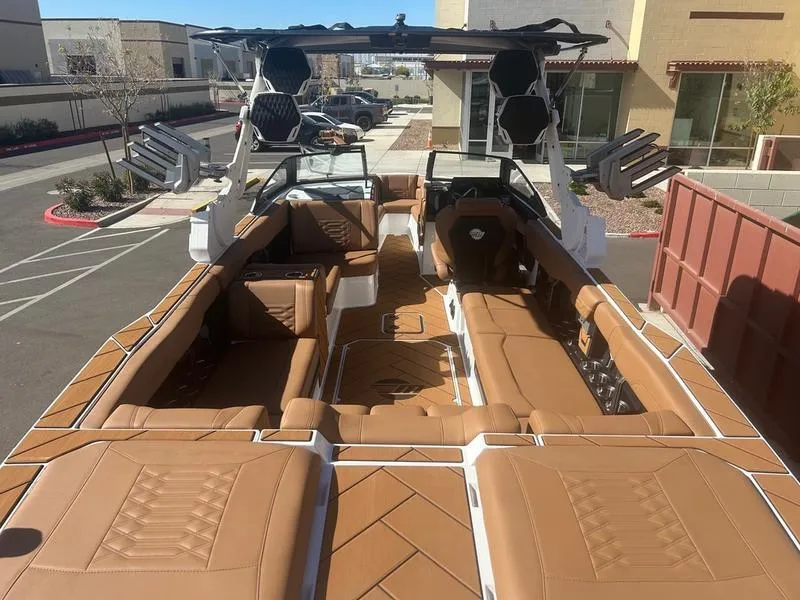 Slide: The Image of 2025 Malibu 26 LSV boat with luxurious tan interior and spacious seating. - 10