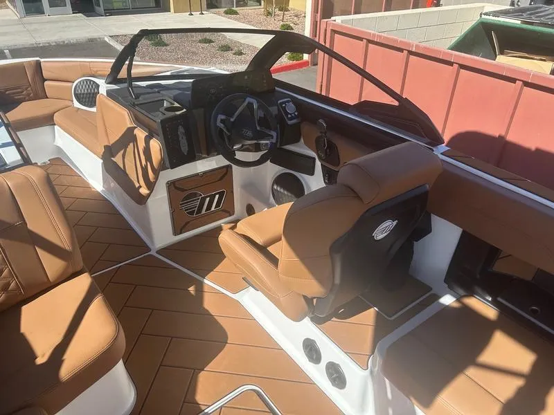Slide: The Image of 2025 Malibu 26 LSV boat interior with tan leather seating and modern dashboard. - 11