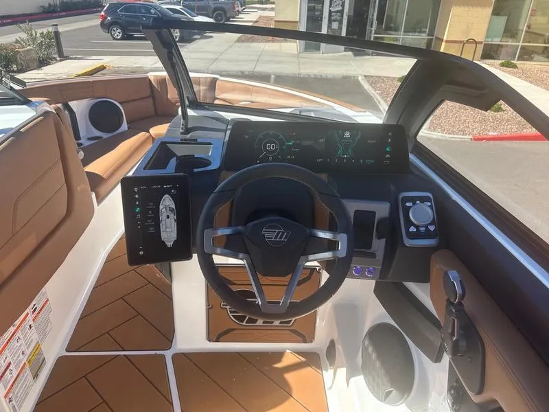 Slide: The Image of 2025 Malibu 26 LSV boat dashboard with modern controls and brown seating. - 12