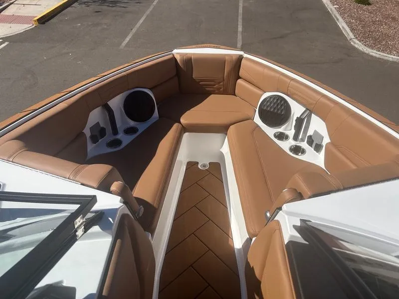 Slide: The Image of 2025 Malibu 26 LSV boat interior with tan leather seating and built-in speakers. - 14