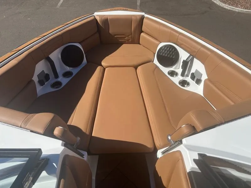 Slide: The Image of 2025 Malibu 26 LSV boat interior with tan leather seating and built-in speakers. - 15