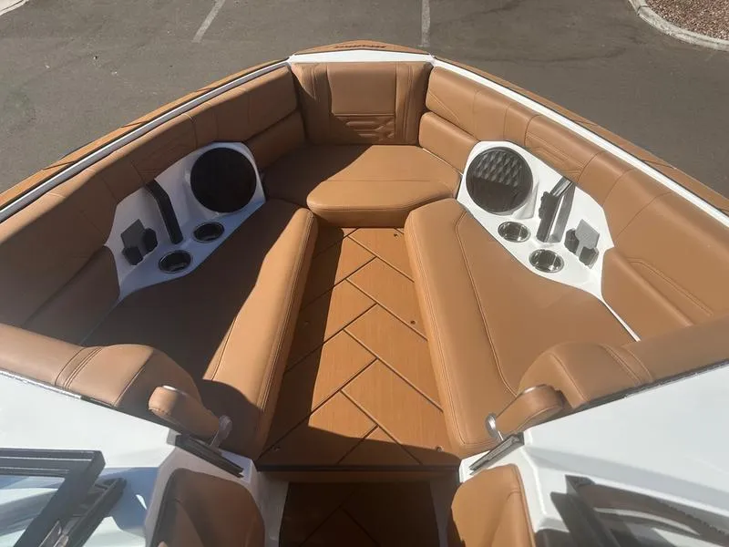 Slide: The Image of 2025 Malibu 26 LSV boat interior with tan leather seating and cup holders. - 16