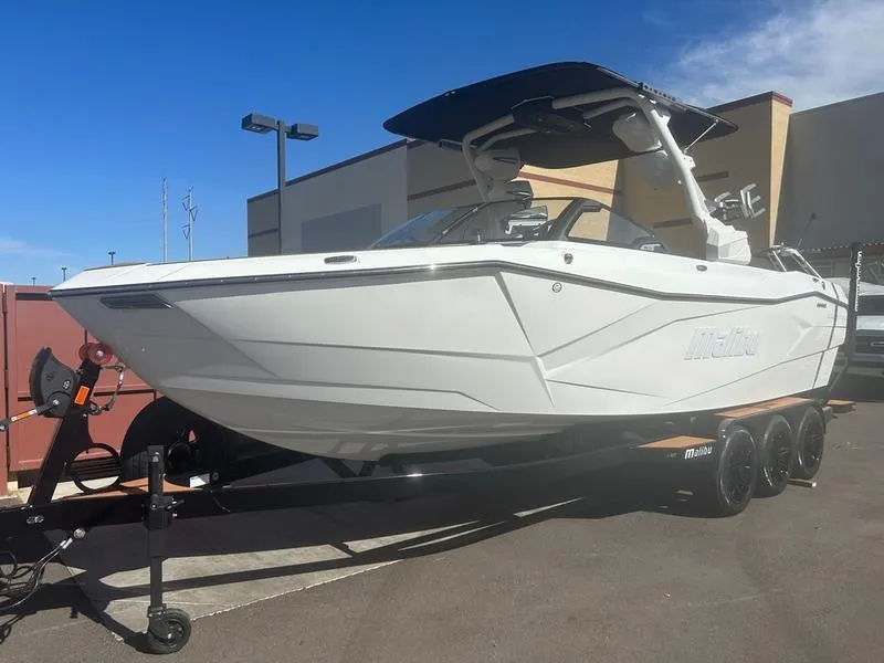 Slide: The Image of 2025 Malibu 26 LSV boat on trailer, white exterior, parked outdoors. - 3