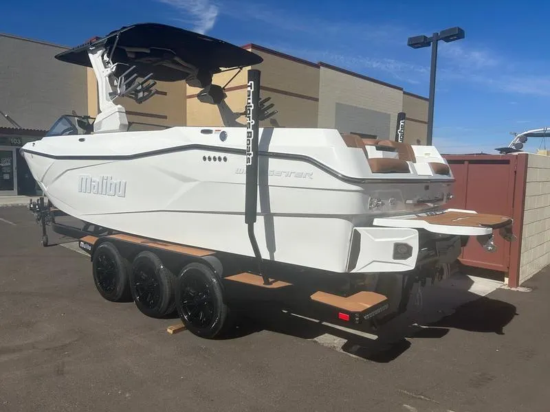Slide: The Image of 2025 Malibu 26 LSV boat on trailer, parked outdoors, showcasing sleek design and modern features. - 4