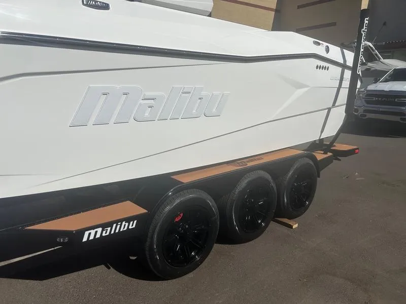 Slide: The Image of 2025 Malibu 26 LSV boat on a triple-axle trailer, side view. - 5