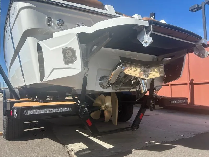 Slide: The Image of 2025 Malibu 26 LSV boat on trailer, rear view showing propeller and hull design. - 7