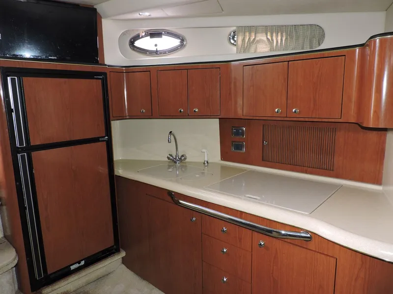 Slide: The Image of 2002 Sea Ray 410 Sundancer yacht kitchen with wood cabinets and modern appliances. - 3