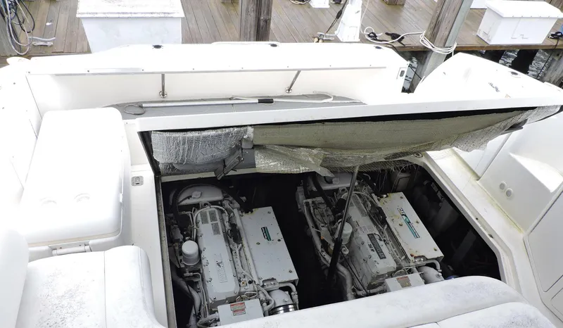 Slide: The Image of 2002 Sea Ray 410 Sundancer engine compartment with twin engines visible at dock. - 7
