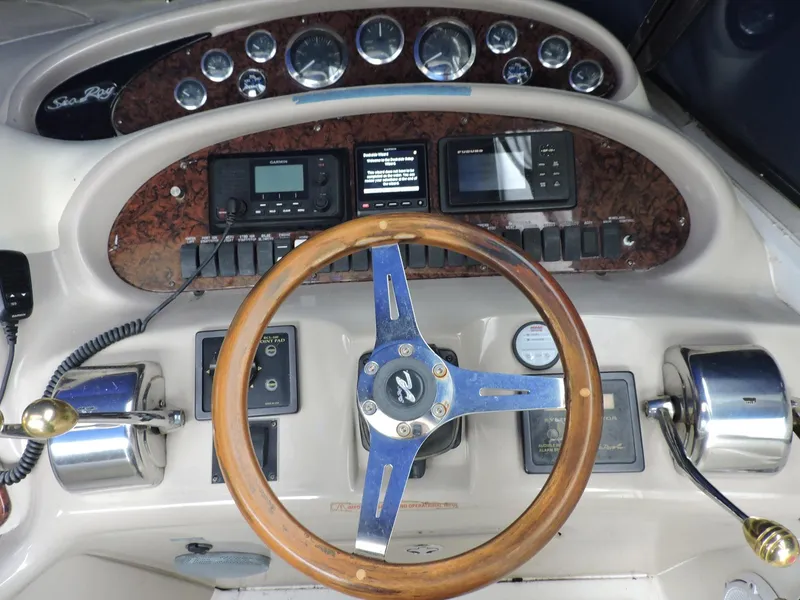 Slide: The Image of 2002 Sea Ray 410 Sundancer helm with wood steering wheel and control panel. - 8