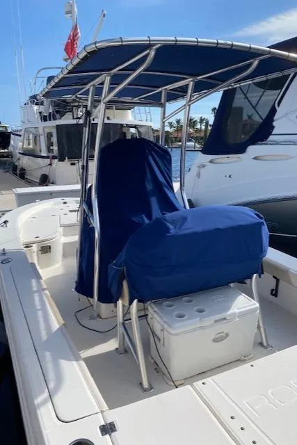 Slide: The Image of 2016 Robalo 226 Cayman boat with blue covers docked at marina. - 10