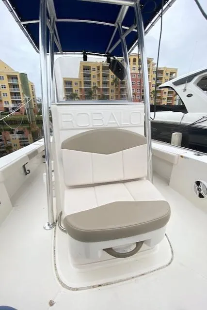 Slide: The Image of 2016 Robalo 226 Cayman boat interior with cushioned seating and canopy. - 19