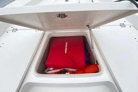 Slide: The Image of Open storage compartment on 2016 Robalo 226 Cayman boat with safety gear inside. - 22