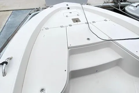 Slide: The Image of 2016 Robalo 226 Cayman boat deck with storage compartments and clean white finish. - 23