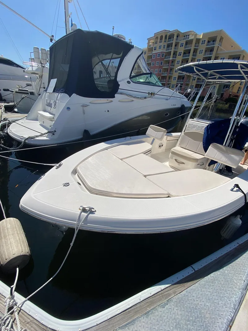 Slide: The Image of 2016 Robalo 226 Cayman boat docked at marina, surrounded by other vessels. - 24