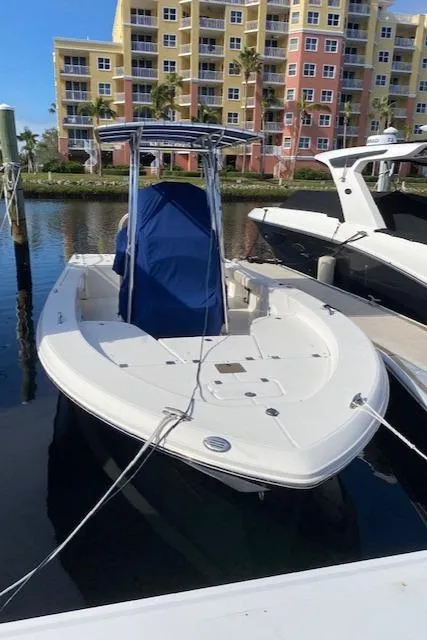 Slide: The Image of 2016 Robalo 226 Cayman boat docked in marina, with colorful buildings in background. - 7
