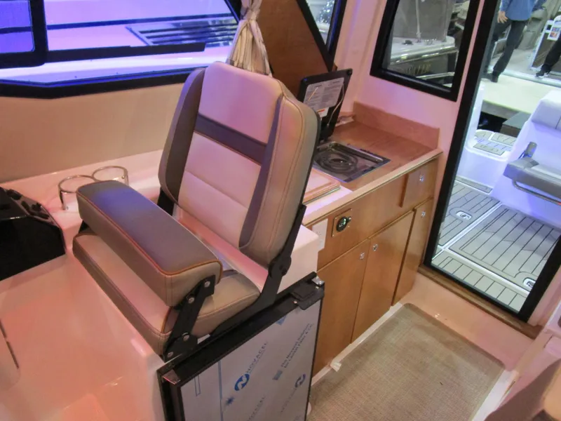 Slide: The Image of Interior of 2025 Cutwater C-248 Coupe featuring helm seat and compact kitchenette. - 22