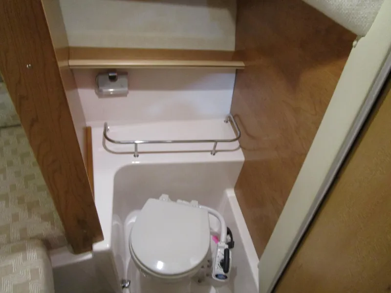 Slide: The Image of 2025 Cutwater C-248 Coupe boat interior bathroom with compact toilet and wooden accents. - 31