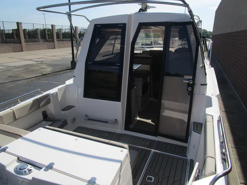 Slide: The Image of 2025 Cutwater C-248 Coupe boat with open cabin door, docked outdoors. - 47