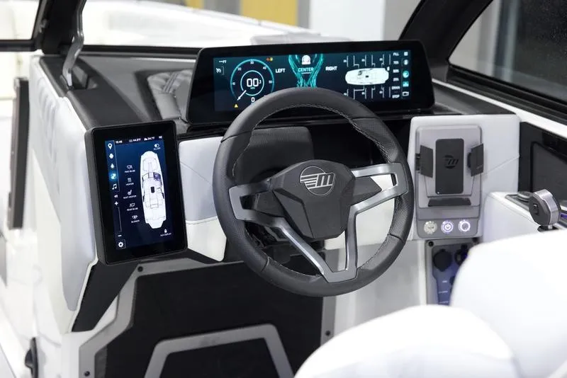 Slide: The Image of 2025 Malibu M242 boat dashboard with digital displays and modern steering wheel. - 14