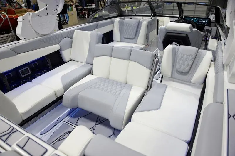 Slide: The Image of 2025 Malibu M242 boat interior with luxurious white and gray seating. - 21
