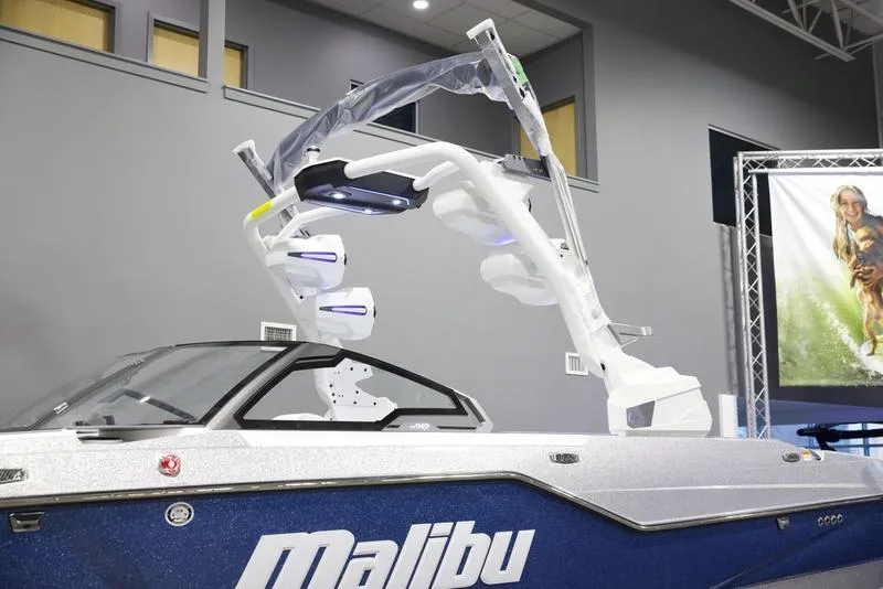 Slide: The Image of 2025 Malibu M242 boat with sleek design and advanced features in showroom setting. - 8