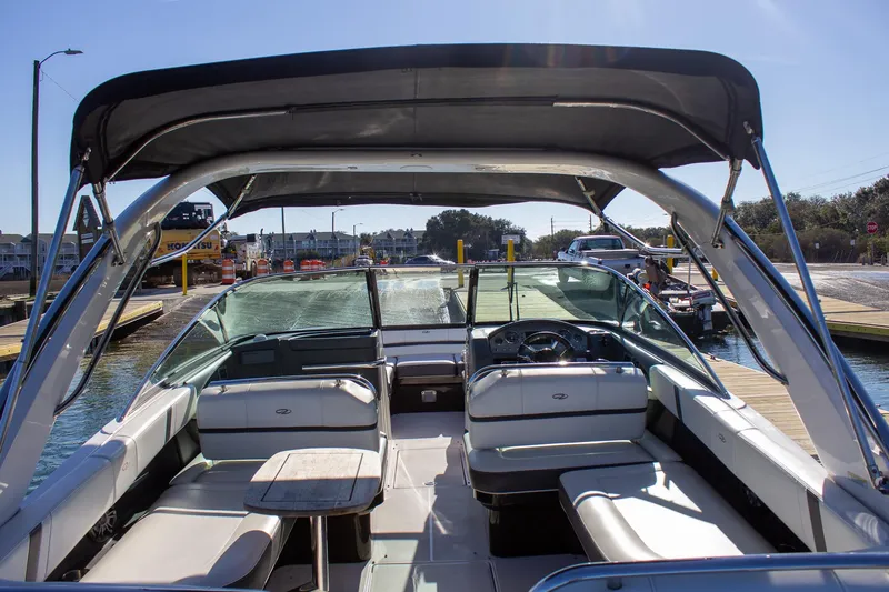 Slide: The Image of 2015 Regal 2800 boat interior with seating and canopy, docked at a marina. - 15