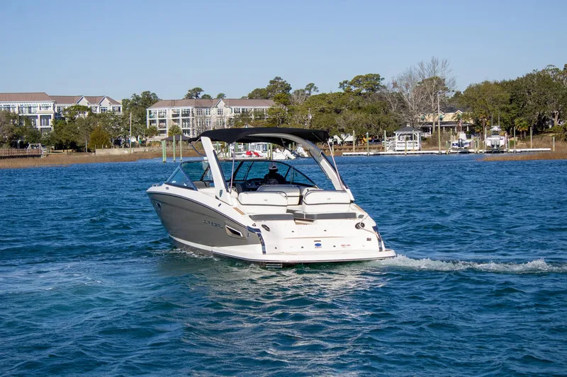 Slide: The Image of 2015 Regal 2800 boat cruising on a sunny day near waterfront homes. - 3