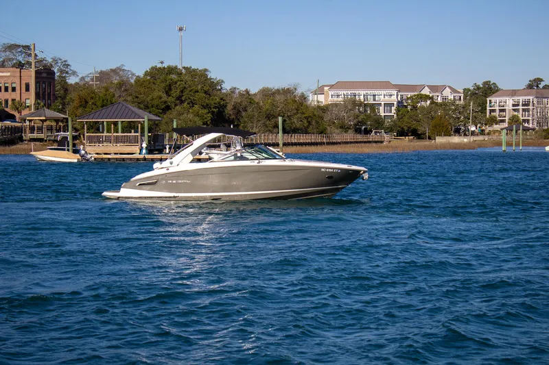Slide: The Image of 2015 Regal 2800 boat cruising on a sunny day near waterfront homes. - 7