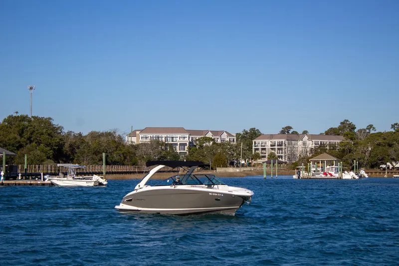 Slide: The Image of 2015 Regal 2800 boat cruising on a sunny day near waterfront homes. - 8