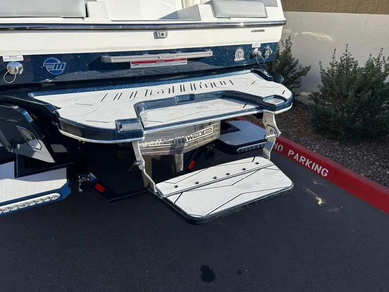 Slide: The Image of 2025 Malibu 24 MXZ boat with swim platform and Wedge system, parked in no parking zone. - 10