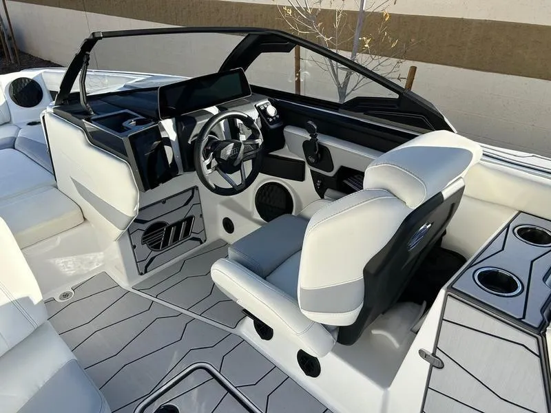 Slide: The Image of 2025 Malibu 24 MXZ boat interior with modern steering and seating. - 12