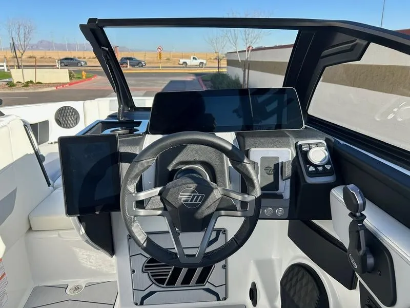 Slide: The Image of 2025 Malibu 24 MXZ boat dashboard with modern steering and digital displays. - 13